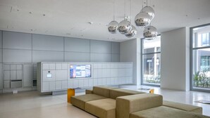 Un espace d’attente moderne doté d’un grand espace de sièges, d’un écran numérique et offrant une vue sur l’extérieur.