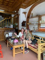 A cozy interior with wooden furniture, a reception desk, and shelves stocked with various items.
