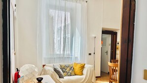 Ein gemütliches Zimmer mit einem Bett, einem Schreibtisch mit Computer und einem Stuhl.