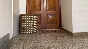 Una puerta doble de madera, con un ojo de cerradura y un pequeño ventanal en la parte superior.