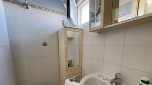 Une petite salle de bain avec des toilettes, un lavabo et un miroir.