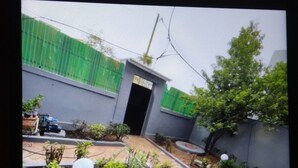 A courtyard with a pathway, potted plants, and a small building with a door. - The Furnished Residences of Fasso Kanu -villa (Bamako)