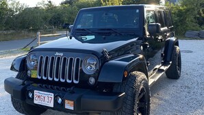 A black Jeep with a license plate reading "2MGX37" parked on a gravel surface. - Private Modern Bedroom In a Central Location (Nantucket)