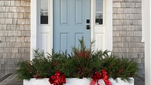 A front door with a number 74, flanked by two white planters with red bows and greenery. - Private Modern Bedroom In a Central Location (Nantucket)