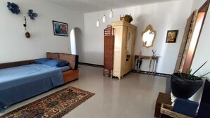 Une chambre à coucher avec un lit, une commode, un miroir et un tapis.