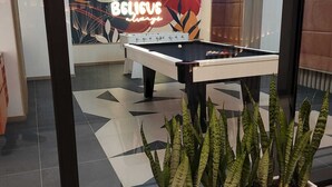 A pool table in a room with a modern design, including a geometric tile floor and a wall with a colorful abstract mural. - Hermosa Suite en la Carolina. Choita Hospedajes (Quito)