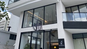 A modern building with multiple balconies, large windows, and a visible store front with the name "VIDA". - Hermosa Suite en la Carolina. Choita Hospedajes (Quito)