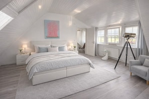 A bedroom with a large bed, a desk, a chair, a telescope, and a window. - Holiday Home "Huus ant Diek" with Private Terrace and Wi-Fi (Norden)