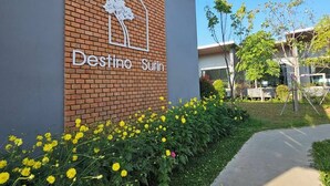 A building with a brick facade and a sign that reads "Destino Surin". - Destino Hotel Surin (Surin)
