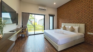 A modern hotel room with a large bed, a flat-screen TV, a desk, and a balcony with a view of the outdoors. - Destino Hotel Surin (Surin)