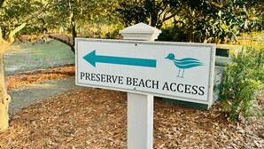 Ein Schild mit der Aufschrift 'PRESERVE BEACH ACCESS' und einem Pfeil.