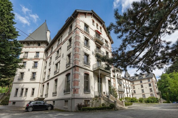 A multi-story building with a classic architectural style, featuring balconies and a staircase leading to the entrance. - La Savoy 1 - Thermes de Saint-Gervais, Saint Gervais Les Bains (Chamonix), France (Saint Gervais Les Bains (Chamonix))