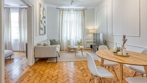 Ett modernt vardagsrum med en soffa, ett soffbord och en matplats.
