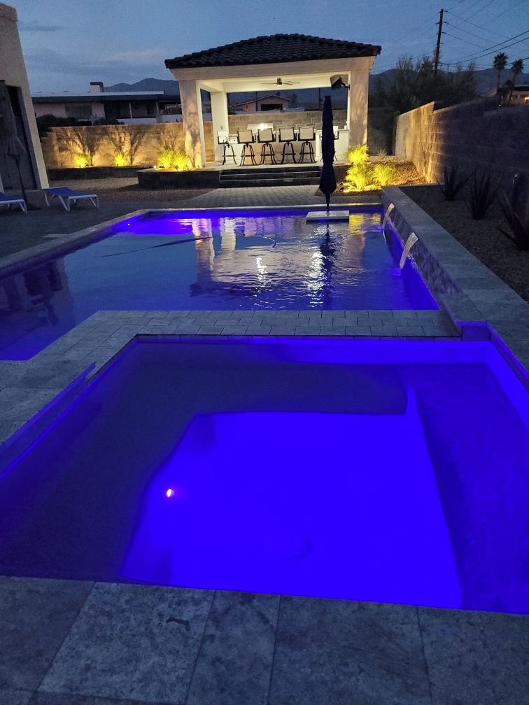 En swimmingpool med en uteplats och ett takförsett sittområde.