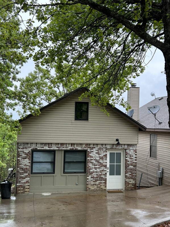 A single-story building with a gabled roof, a small dormer window, and a garage with two roll-up doors.