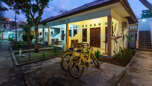Un edificio de dos pisos con un balcón y una bicicleta estacionada adelante.