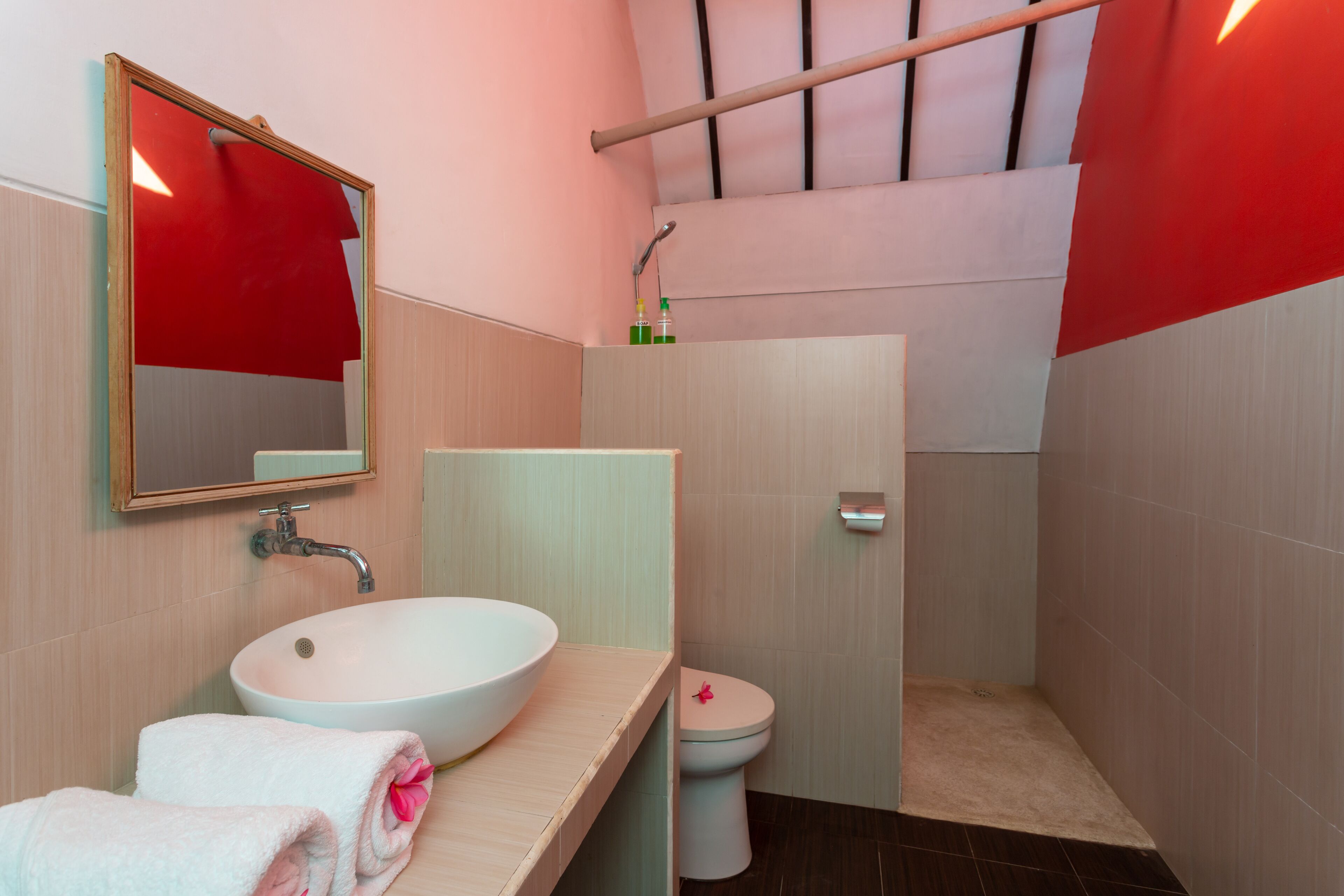 A modern bathroom with a large sink, mirror, toilet, and shower area.