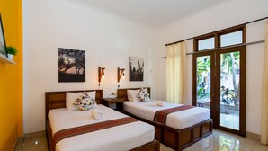 Habitación de hotel con dos camas, una mesita de noche, una ventana con cortinas y una obra de arte en la pared.