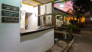Zona de recepción con carteles que anuncian un tour por Lombok, un viaje de snorkel y un servicio de alquiler de bicicletas.