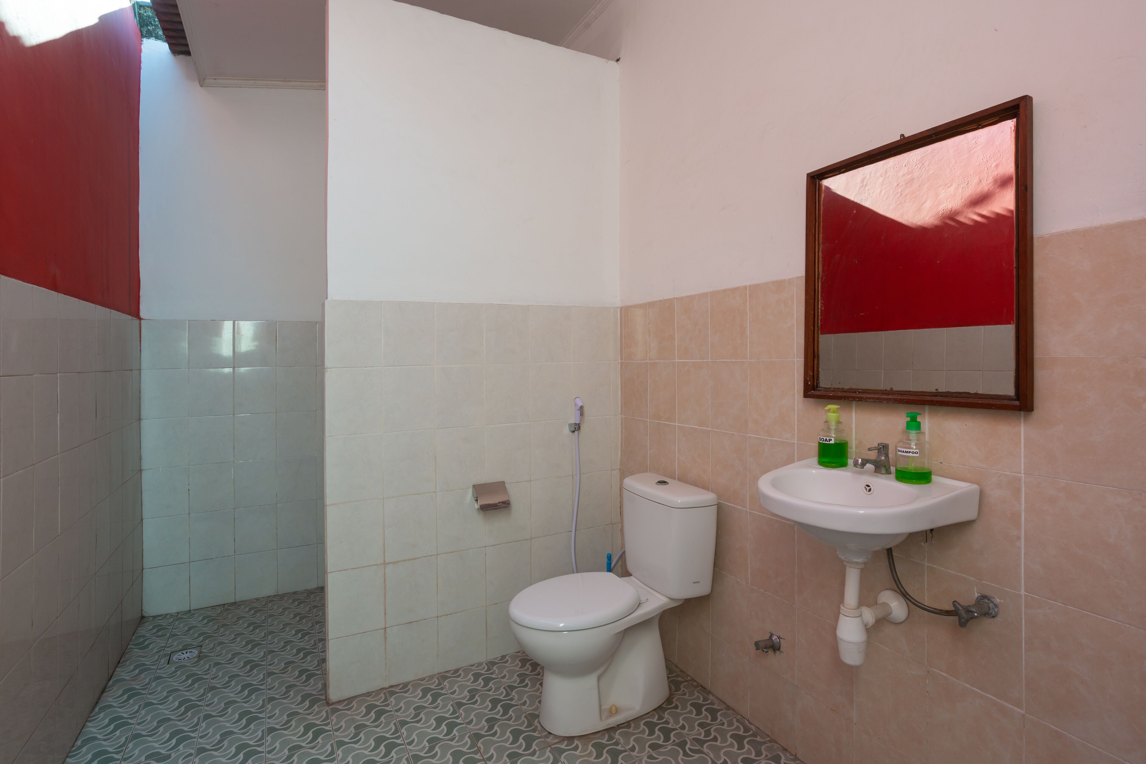 Une salle de bain avec des toilettes, un lavabo et un miroir.