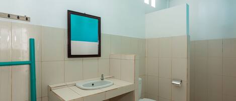 A bathroom with a sink, toilet, and shower area.