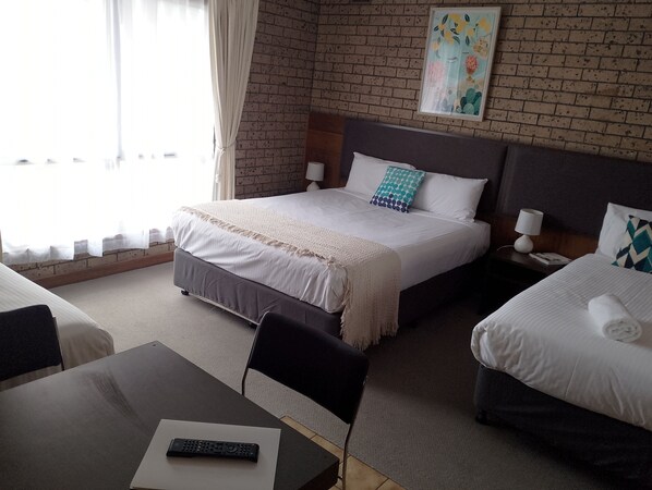A hotel room with a large bed, a smaller bed, a desk with a remote control, and a painting on the wall. - Pan Co Victor Harbor (Victor Harbor)