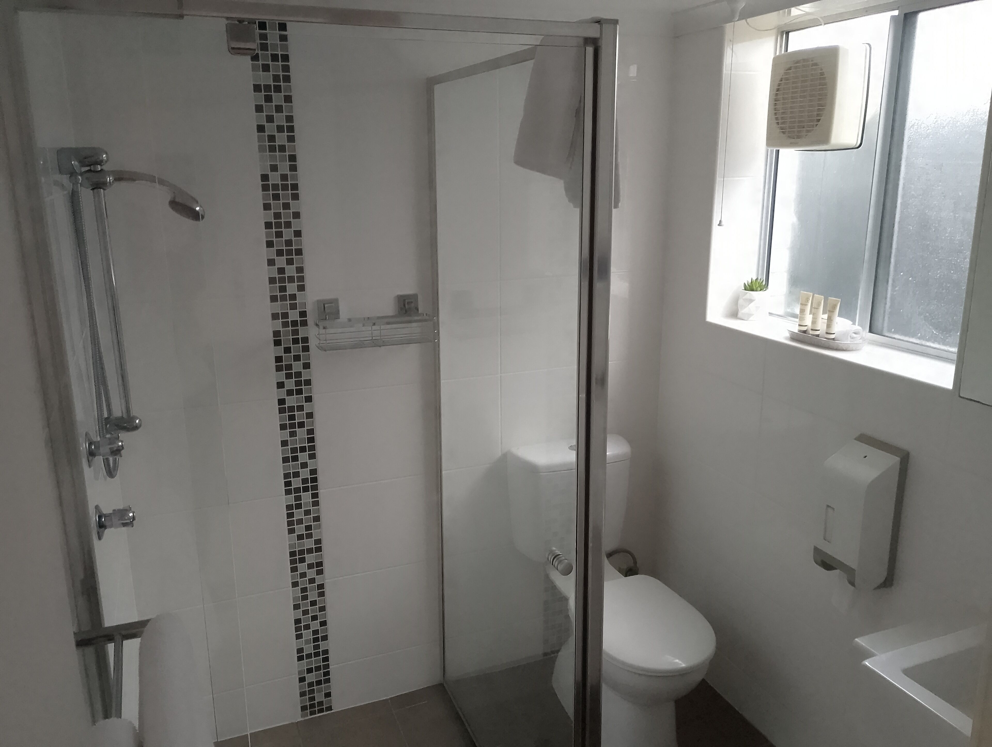 Ein modernes Badezimmer mit einer Duschkabine, einer Toilette und einem Waschbecken.