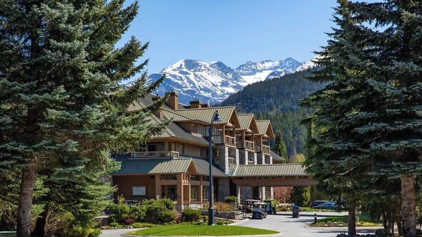 A lodge with a stone facade, multiple stories, and a prominent entrance. - Green Lake condo w/ panoramic views (Whistler)