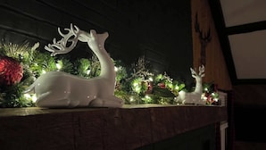 A fireplace mantel decorated with a white ceramic deer figurine and Christmas ornaments. - Far View Shenandoah | Hot Tub, Movie & Game Room, Valley Views | 3BR & Sleeps 6 (Front Royal)