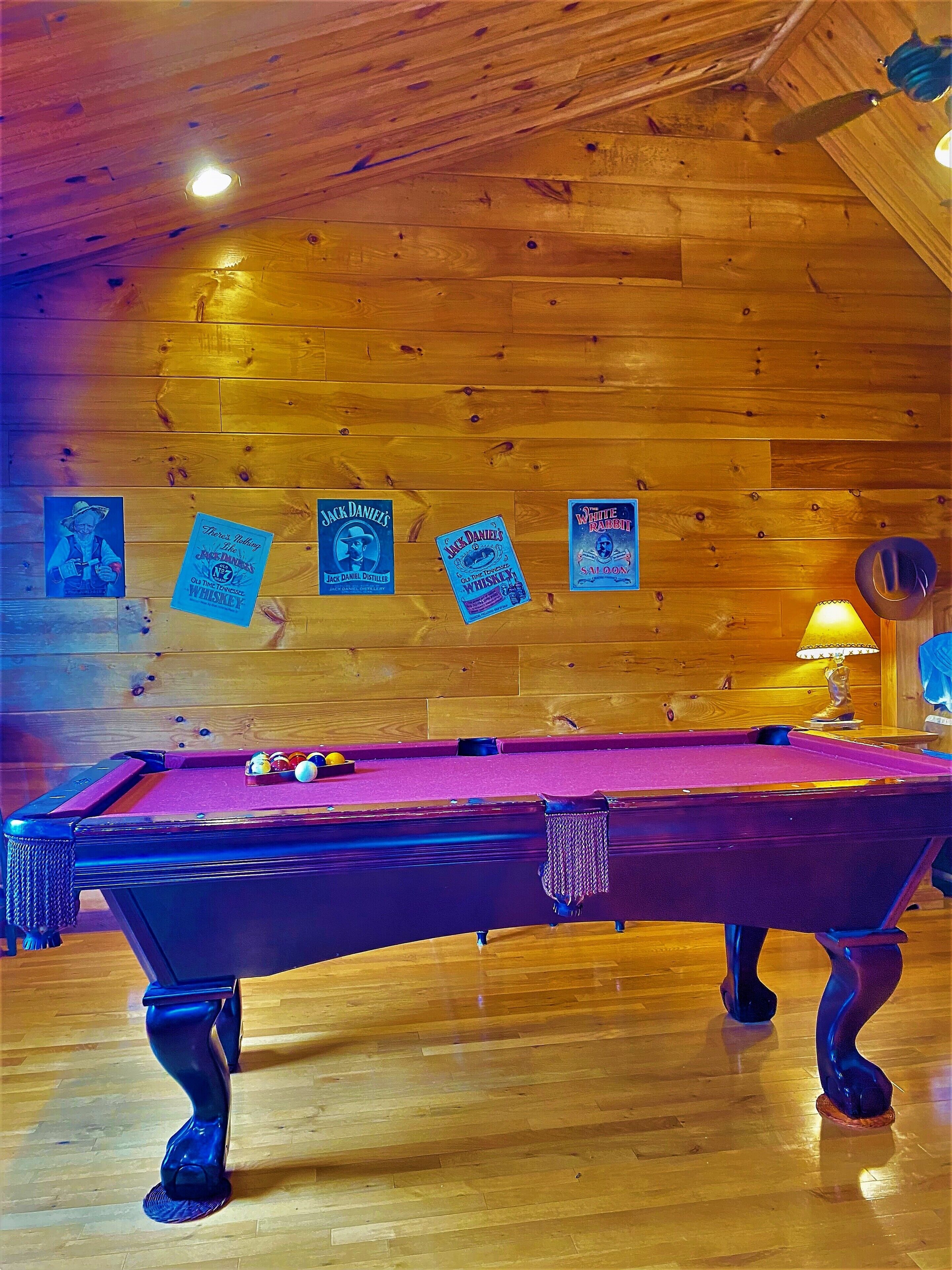 Ein Billardtisch mit Holzboden, -decken und -wänden.