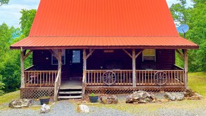 Una cabaña de madera con techo rojo y un porche, con la leyenda 'WILD WEST'.