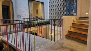 Un espace extérieur moderne comprenant un escalier, un mur décoratif et un coin salon avec une table et des chaises.