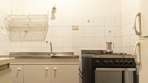 A kitchen with white cabinets, a stove, and a sink. - Carlotta, apartment a few steps from the pedestrian center of Marina di Campo equipped with air cond (Marina di Campo)