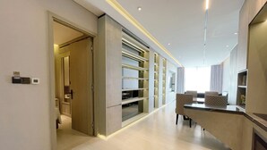Une chambre d’hôtel moderne, dotée d’un aménagement spacieux, d’un téléviseur intégré et d’un coin salon avec un canapé et des fauteuils.