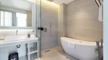 A modern bathroom with a freestanding bathtub, a large mirror, and a glass shower enclosure.