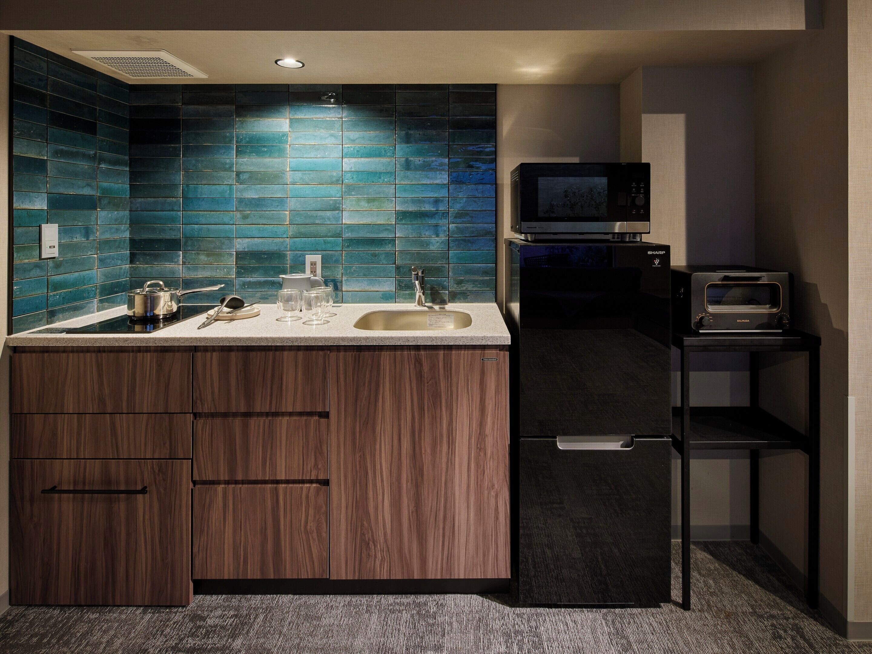 A modern kitchen with a built-in microwave, a sink, and wooden cabinets.