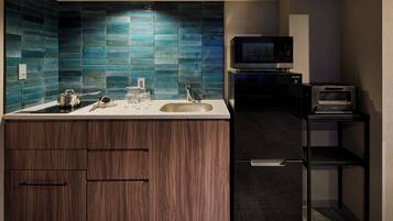 A modern kitchen with a built-in microwave, a sink, and wooden cabinets.