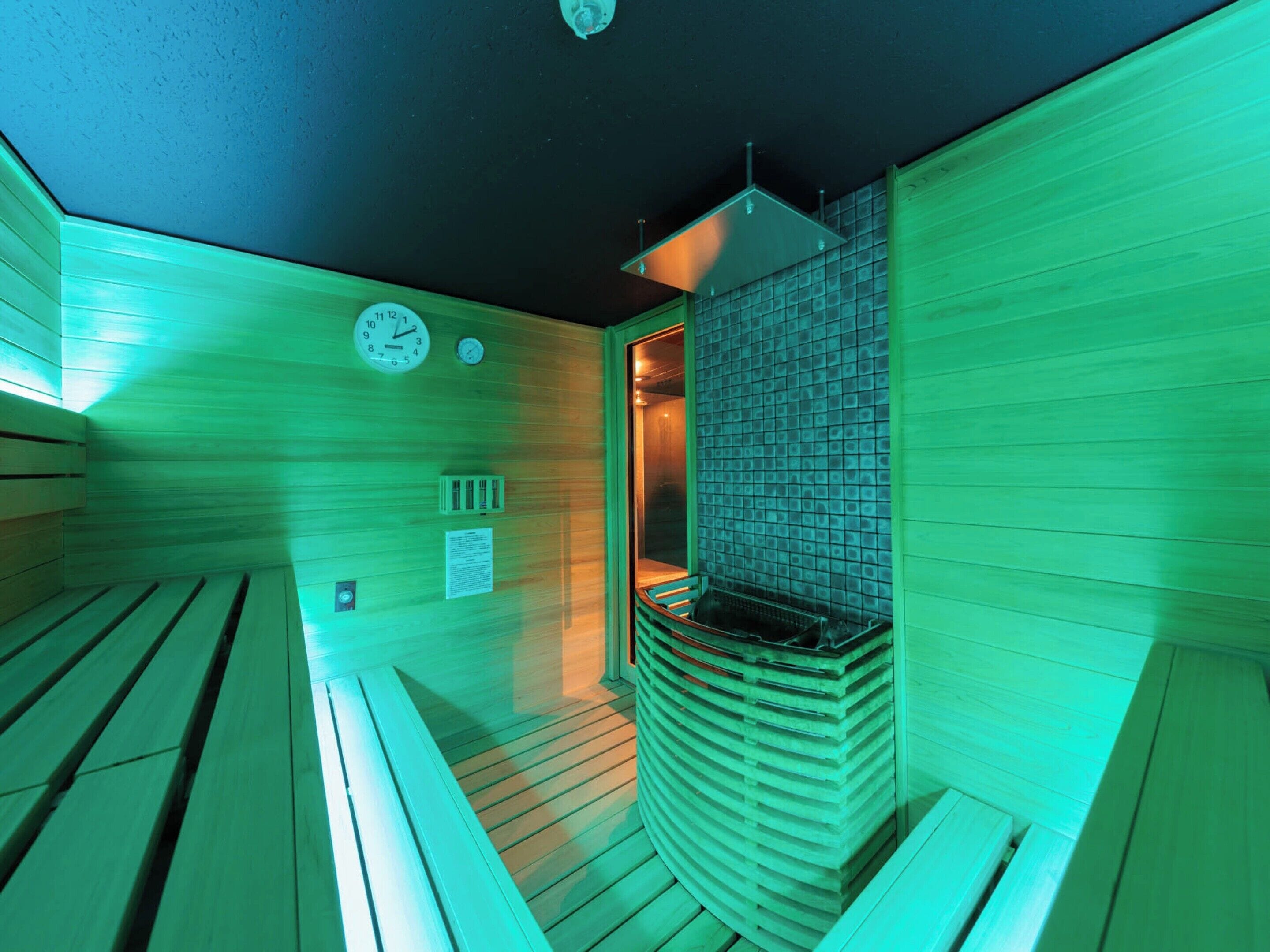 Una sauna con bancos de madera y pared de azulejos.
