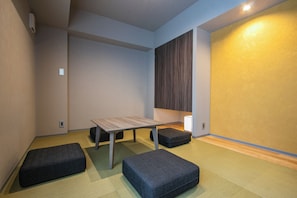 Relax in a stylish space with a central table, dark grey ottomans, and a light-colored carpet.