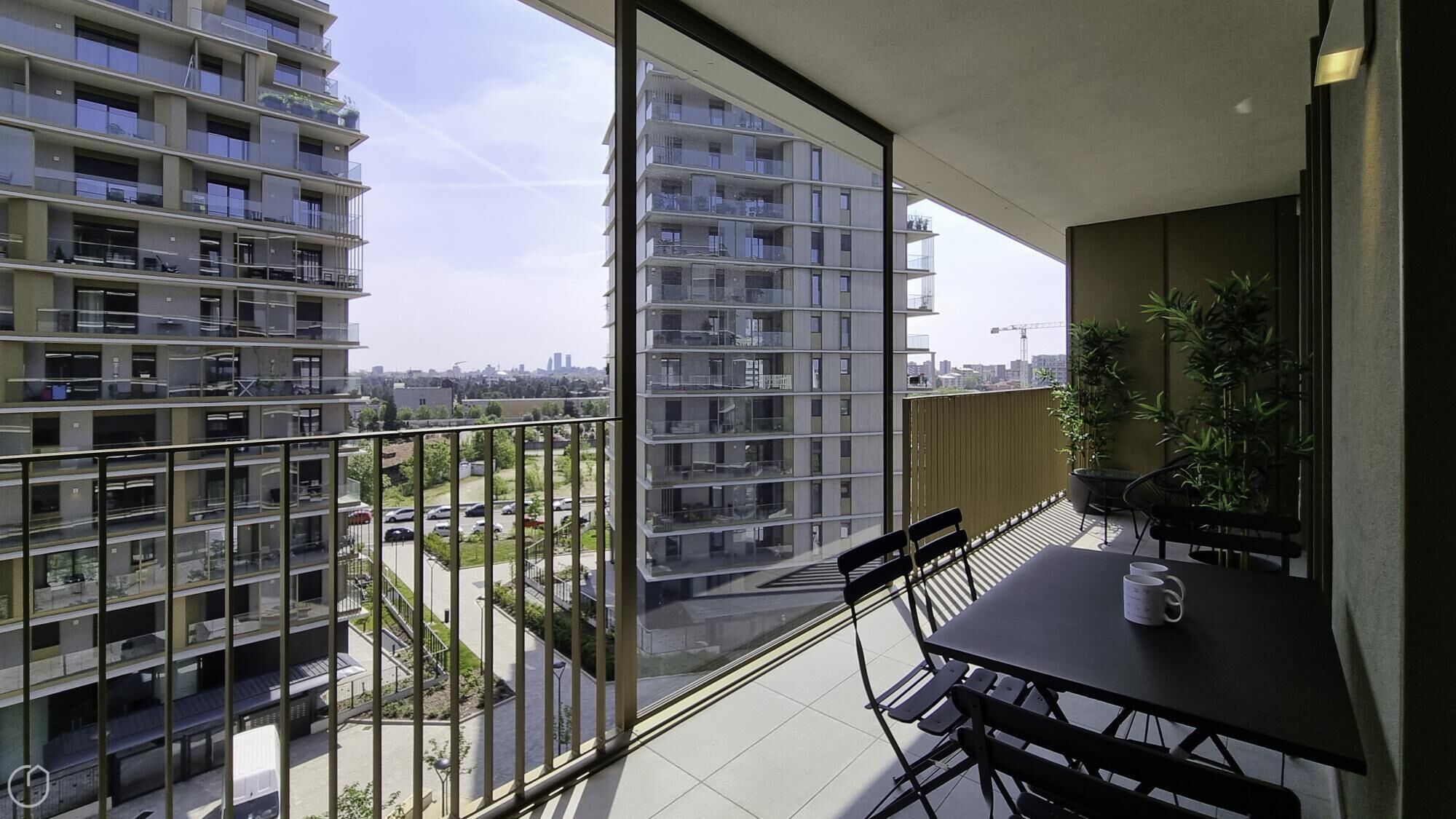 Un apartamento moderno con balcón, ventanas amplias y vista a otros edificios.