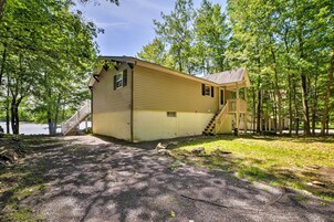 A cabin with a porch and a staircase leading to the entrance.