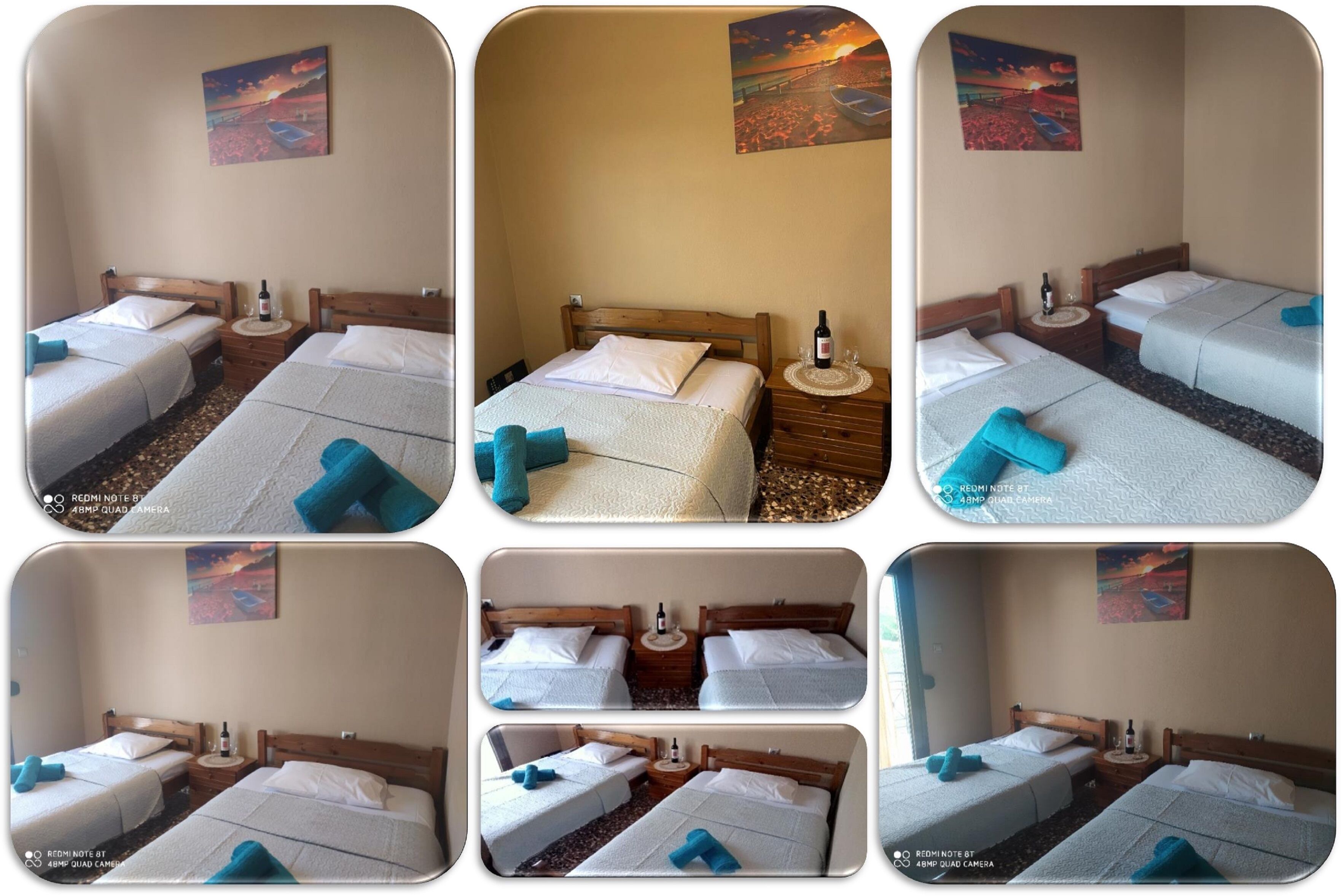 A hotel room with two single beds, a wooden headboard, a small bedside table with a bottle, and a wall painting.