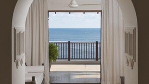 A room with a view of the ocean through an arched doorway, a ceiling fan, and a potted plant. - Saffron House in Weligama (Weligama)