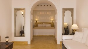 A hotel room with a large bed, two bedside lamps, a nightstand, and a mirror on the left wall. - Saffron House in Weligama (Weligama)