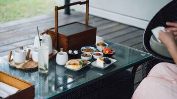 A dining table with various dishes and drinks, a coffee maker, and a teapot.