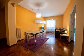Un espacio habitable compacto con comedor, una kitchenette pequeña y una zona de descanso.