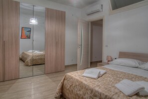 Relax in a serene bedroom with a large bed, a wooden wardrobe, and a bedside table.