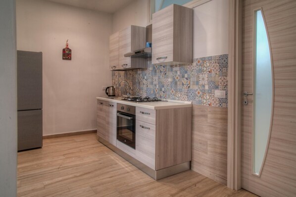 Kitchen features an oven, compact island with sink, and stainless steel appliances.