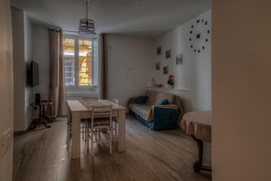 Cozy living space with a dining area and seating area, featuring a dining table and sofa.