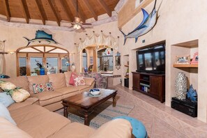 A spacious living room with a large sofa, a coffee table, and a television.
